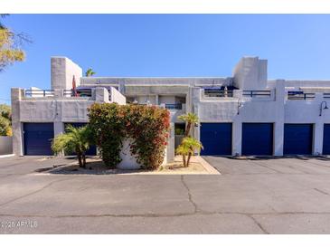 View of condominiums with blue doors, bougainvillea and palm trees at 902 W Glendale Ave # 115, Phoenix, AZ 85021