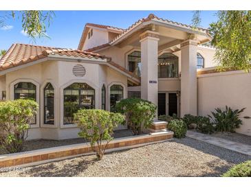 Inviting two-story home showcasing stucco exterior, tile roof, arched windows, and manicured landscaping at 1327 E Le Marche Ave, Phoenix, AZ 85022