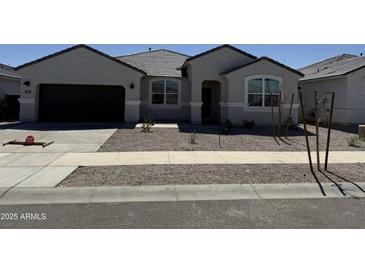 Charming single-story home with a well-maintained front yard and a two-car garage at 15381 W Cottontail Ln, Surprise, AZ 85387