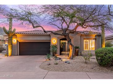 Charming home featuring a well-maintained landscape with desert plants and a secure, gated entryway at 16013 N 111Th Pl, Scottsdale, AZ 85255