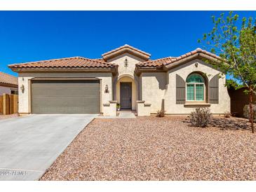 Charming single-story home with a well-maintained front yard, desert landscaping, a two-car garage, and a tile roof at 1980 E Horseshoe Dr, Chandler, AZ 85249
