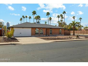 Charming single-story brick home with a well-maintained front yard, palm trees and attached garage at 2405 E Balboa Dr, Tempe, AZ 85282