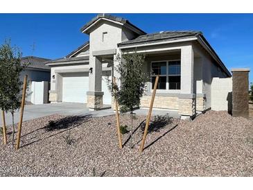 Charming single-story home featuring a two-car garage, stone accents, and desert landscaping at 5009 S 106Th Ave, Tolleson, AZ 85353