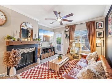 Cozy living room featuring a fireplace, ceiling fan, and comfortable seating at 9451 E Becker Ln # 2013, Scottsdale, AZ 85260