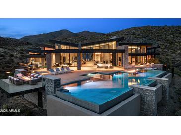 Stunning modern home featuring an infinity pool, outdoor seating, and mountain views at twilight at 9643 E Cintarosa Pass, Scottsdale, AZ 85262