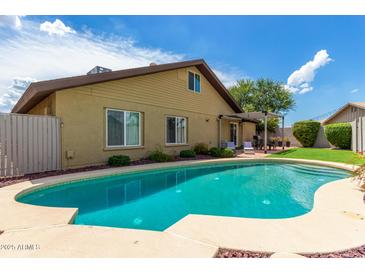 Inviting backyard pool with lush landscaping, perfect for relaxing and entertaining in a private outdoor oasis at 2644 E Sylvia St, Phoenix, AZ 85032
