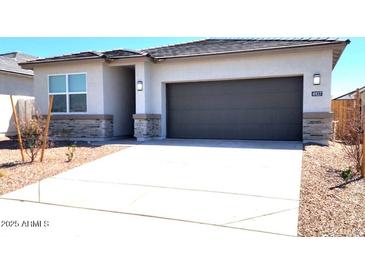 Charming single-story home with neutral stucco, stone accents, and a two-car garage at 4927 S 106Th Ave, Tolleson, AZ 85353