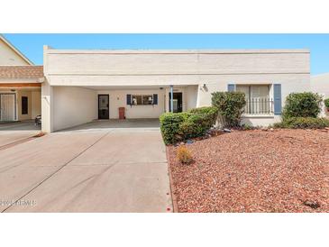 A cozy single-story house featuring an attached carport, desert landscaping, and a covered front entryway at 5032 N 78Th St, Scottsdale, AZ 85250