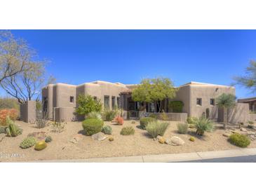 Desert home featuring unique architecture, native landscaping, and neutral earth tone color palette on a sunny day at 7373 E Clubhouse Dr # 24, Scottsdale, AZ 85266