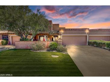Charming single-story home with lush lawn, mature tree, and two-car garage at sunset at 7725 N Via De Fonda --, Scottsdale, AZ 85258