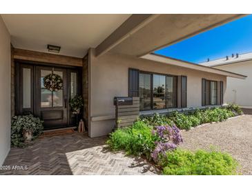 Inviting home entrance with wood accents, stylish door, and lovely landscaping enhancing curb appeal at 8238 E San Miguel Ave, Scottsdale, AZ 85250