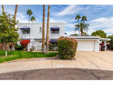 Charming two-story home with a well-manicured lawn and beautiful mature trees creating great curb appeal at 8438 E Stella Ln, Scottsdale, AZ 85250