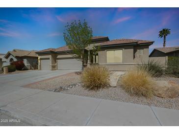 Charming single-story home featuring a three-car garage and xeriscaped front yard, perfect for low-maintenance living at 14442 W Lexington Ave, Goodyear, AZ 85395