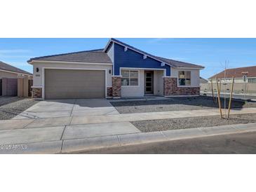 Charming single-story home featuring blue accent siding and a two-car garage at 14761 W Tether Trl, Surprise, AZ 85387