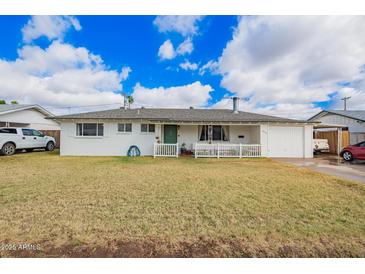 Charming single-story home featuring a welcoming porch, a well-maintained lawn, and an attached garage with an open carport at 1840 E Jarvis Ave, Mesa, AZ 85204