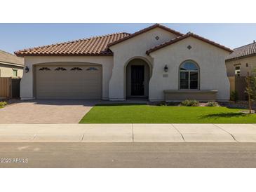 Charming single-story home features a tile roof, arched entry, and well-manicured artificial lawn at 2887 W Chevelon Dr, Queen Creek, AZ 85144