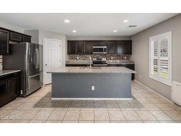 A well-lit kitchen featuring stainless steel appliances, granite countertops, tile backsplash, and a spacious center island at 2929 E Binner Dr, Chandler, AZ 85225
