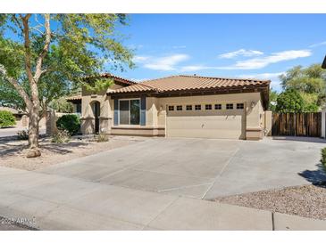 Charming single-story home with a tile roof, tan stucco, and a spacious two-car garage at 2994 E Sports Ct, Gilbert, AZ 85298