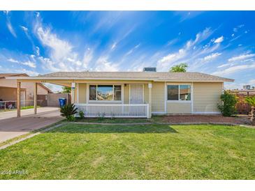 Charming single-story home with a well-manicured lawn and a white picket fence at 332 N 25Th St, Mesa, AZ 85213