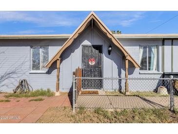 Charming home featuring a secure gated front porch and light blue exterior paint at 5517 N 61St Ln, Glendale, AZ 85301