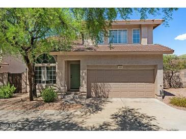 Charming two-story home featuring a well-maintained front yard, a two-car garage, and a welcoming entrance at 7650 E Williams Dr # 1038, Scottsdale, AZ 85255