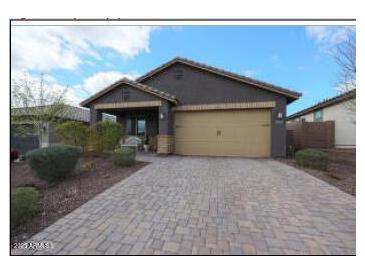 Charming single-story home featuring a brick driveway, desert landscaping, and a two-car garage at 8490 S 165Th Dr, Goodyear, AZ 85338