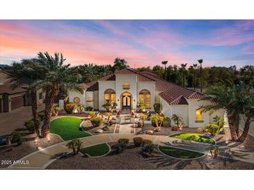 Elegant home showcasing desert landscaping, a circular driveway, and a red tile roof under a vibrant sunset sky at 11319 E Elmhurst Dr, Chandler, AZ 85249