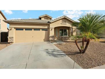 Charming single-story home featuring a two-car garage and desert landscaping at 11564 W Harrison St, Avondale, AZ 85323