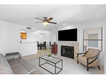 Open concept living room with tile fireplace, ceiling fan, and view to the kitchen and dining room at 14645 N Fountain Hills N Blvd # 215, Fountain Hills, AZ 85268