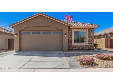 Charming single-Gathering home featuring a two-car garage and stone accents with easy to maintain desert landscaping at 16573 W Alameda Rd, Surprise, AZ 85387