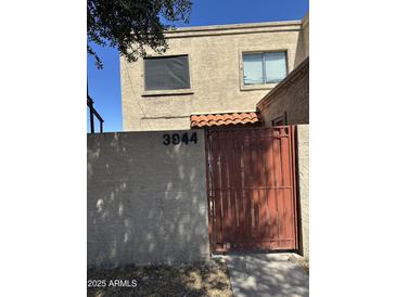 Exterior view of a two-story home featuring a gated entrance and visible house number at 3944 W Camelback Rd, Phoenix, AZ 85019