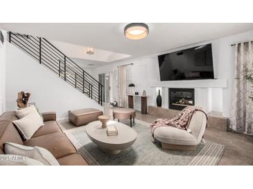 Stylish living room featuring a modern fireplace, sleek furniture, and plenty of natural light at 7650 E Williams Dr # 1011, Scottsdale, AZ 85255