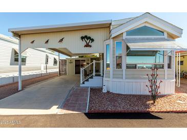 Charming manufactured home features covered parking, a porch, and attractive desert landscaping at 9736 E Main St # 43, Mesa, AZ 85207