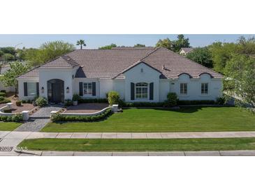 Charming single-story home with lush green lawn, neutral paint, and a tile roof at 3173 E Page Ave, Gilbert, AZ 85234