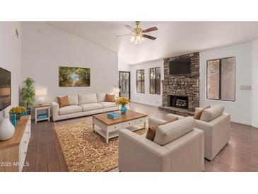 Bright living room with stone fireplace, large windows, and hardwood floors at 4450 E Amberwood Dr, Phoenix, AZ 85048