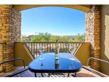 Balcony with a table and chairs, offering a view of the surrounding landscape and clear blue sky at 5450 E Deer Valley Dr # 2023, Phoenix, AZ 85054