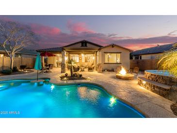 Inviting backyard oasis featuring a sparkling pool, spa, fire pit, and covered patio perfect for outdoor entertaining at 560 W Powell Way, Chandler, AZ 85248