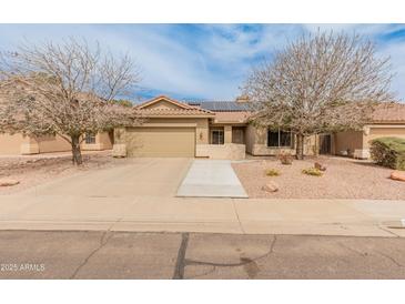 Charming single-story home boasts a tile roof, desert landscaping, and solar panels for energy efficiency at 760 W Douglas Ave, Gilbert, AZ 85233