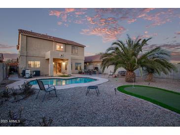 A backyard featuring a private pool, putting green, and well-maintained landscaping at 36469 W Alhambra St, Maricopa, AZ 85138