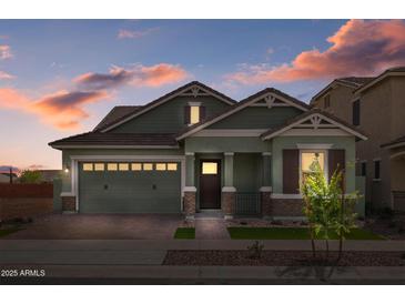 Charming single-Gathering home featuring a two-car garage, stylish wood accents, and beautiful landscaping at dusk at 4265 E John St, Gilbert, AZ 85295