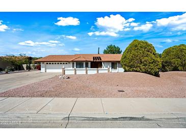 Charming single-story home featuring a tile roof, desert landscaping, and a two-car garage at 5434 E Acoma Dr, Scottsdale, AZ 85254