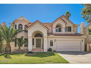 Elegant two-story home with desert landscaping, a terracotta roof, and a two-car garage at 6925 W Tonto Dr, Glendale, AZ 85308