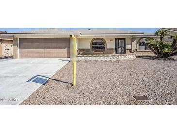 Charming home with a two-car garage, decorative brick accents, and desert landscaping at 8320 E Nido Ave, Mesa, AZ 85209