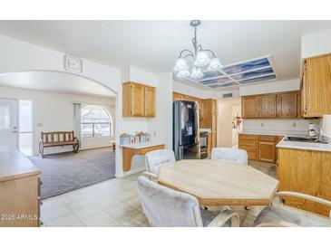 Eat-in kitchen featuring oak cabinets, black appliances, and tiled flooring at 8320 E Nido Ave, Mesa, AZ 85209