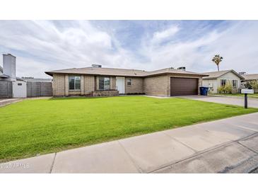 Charming brick home with a lush green lawn, two-car garage, and a welcoming front entrance at 903 W Barrow Dr, Chandler, AZ 85225