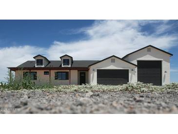 Charming single-Gathering home featuring dormer windows and a three car garage, perfect for a modern lifestyle at 11142 E Copper Dust Trl, Florence, AZ 85132