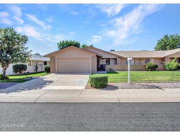 Charming single-story home featuring a well-manicured front yard and attached two-car garage at 12519 W Castle Rock Dr, Sun City West, AZ 85375