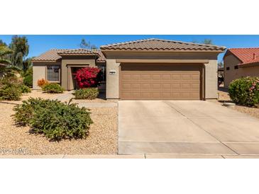 Charming home featuring a two-car garage, manicured front yard, and a desert-style landscape at 15074 W Cactus Ridge Way, Surprise, AZ 85374