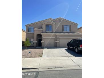 Two-story home featuring a well-manicured front yard, neutral color palette, and attached two-car garage at 19427 N Toya St, Maricopa, AZ 85138