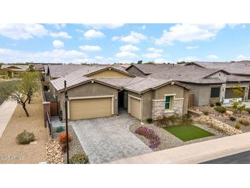Charming home featuring a three-car garage, desert landscaping, and a beautifully paved driveway at 23434 N 76Th Way, Scottsdale, AZ 85255
